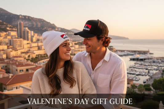 A cute couple sitting on a patio with sweeping views of a mediterranean town. The man is wearing a black monaco snapback hat and the woman is wearing the white niseko toque.